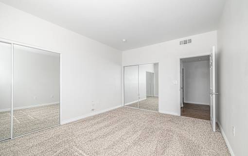 A room with a carpeted floor and a sliding glass door.