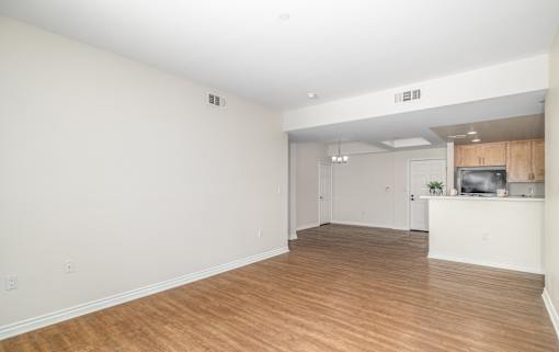 A large empty room with wooden floors and white walls.