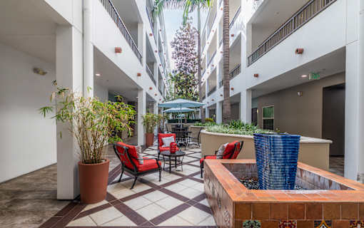 A courtyard with a fountain and chairs.