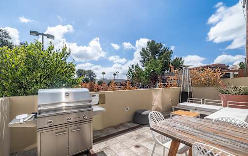 A patio with a grill and a table.