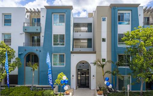 A modern apartment building with balconies and a blue and white facade.