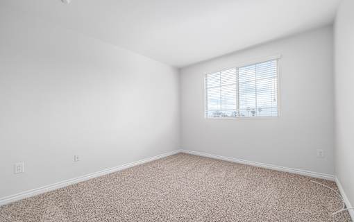 A room with a window and carpeted floor.