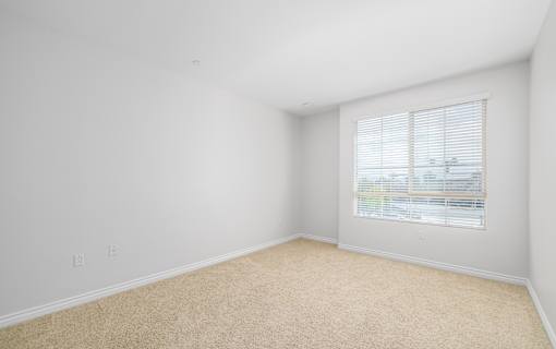 A room with a window covered by blinds.