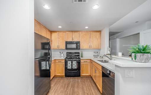 A kitchen with wooden cabinets and black appliances.