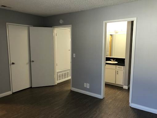A room with a white door and a mirror on the wall.