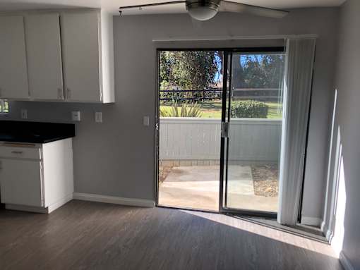 A kitchen with a sliding glass door leading to a backyard.