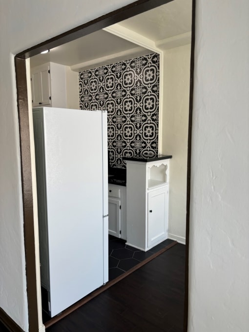 a small kitchen with a white refrigerator and a sink