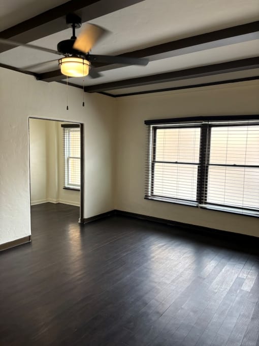 an empty living room with wood floors and a window