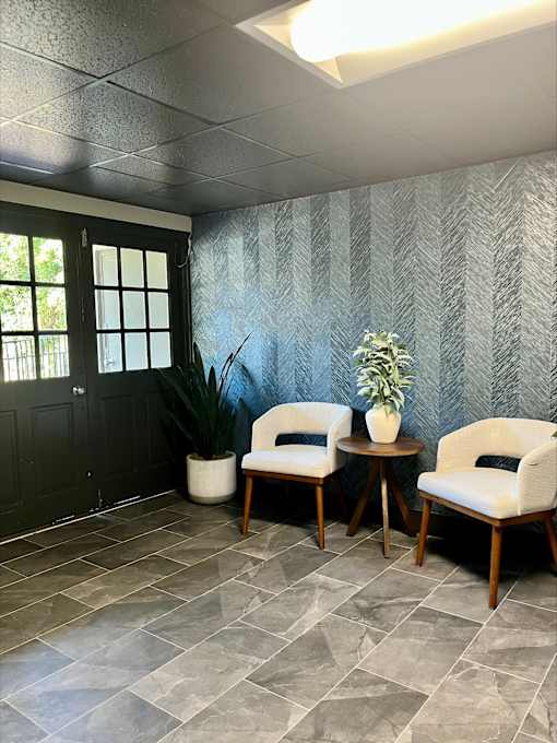 Two chairs and a table with a plant on it.