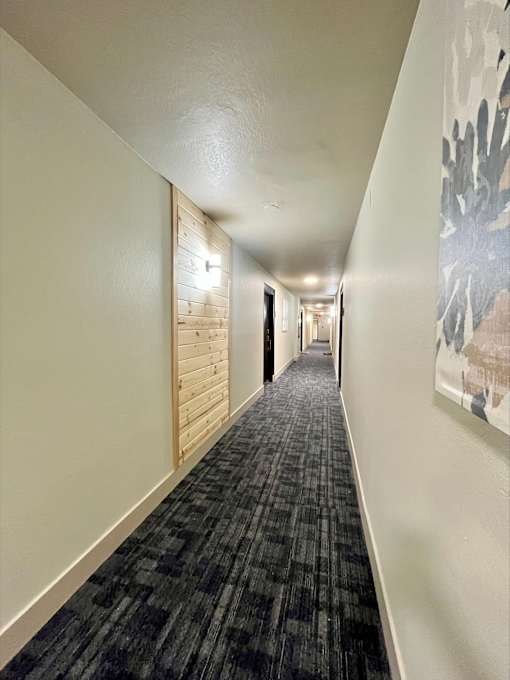A long hallway with a carpeted floor and white walls.