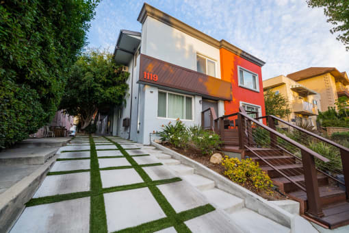 a house with a sidewalk and stairs in front of it