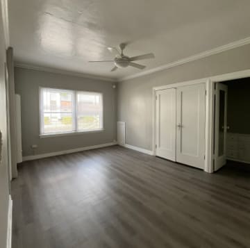 A room with a ceiling fan and a window.