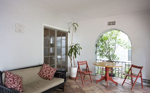 A balcony with a table and chairs.