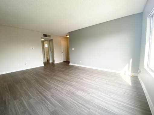 the living room of an empty apartment with wood flooring