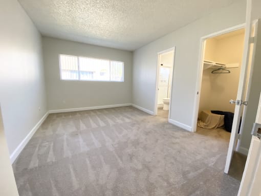 an empty room with a closet and a window