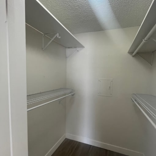 an empty closet with shelves and a shelf on the wall