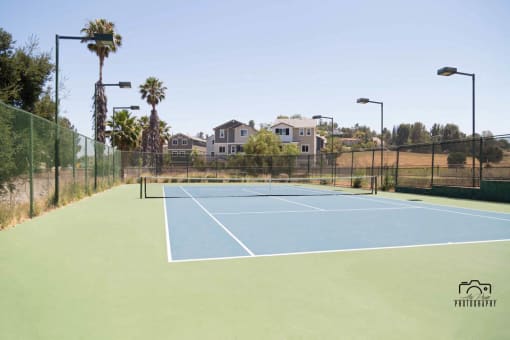 view of tennis court facing apartment community