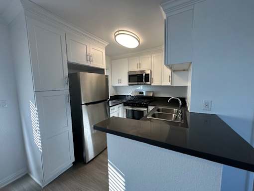 a kitchen with a stainless steel refrigerator and a sink