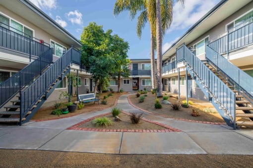 courtyard with benches and trees at the whispering winds apartments in pearland, tx