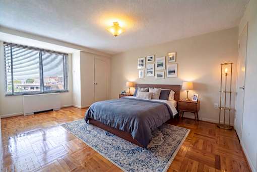 A bedroom with a bed, nightstand, and window.