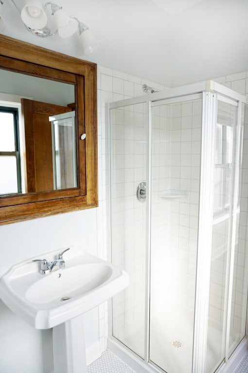 a small bathroom with a white sink and shower
