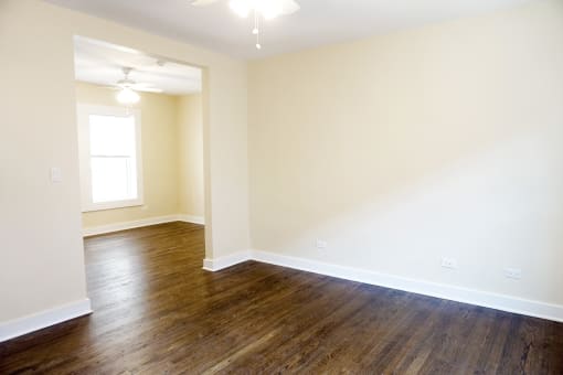 a bedroom with hardwood flooring and a window