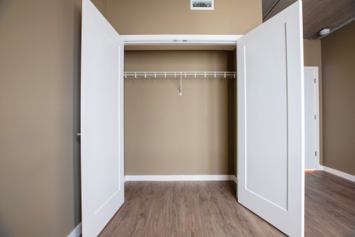 an empty closet with a white door and brown walls