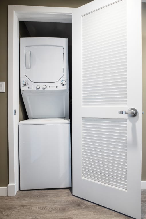 a washer and dryer in a room with a door that is open