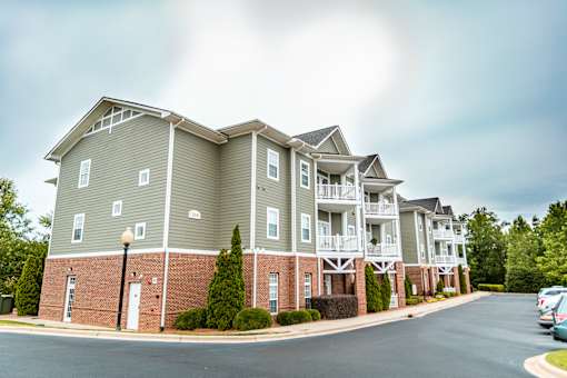 A row of apartment buildings with a street in front.