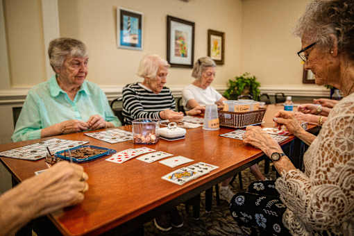 A group of elderly women playing a card game.