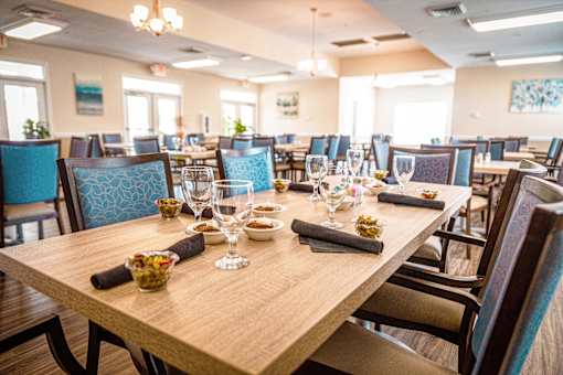 A dining room with a long table set for a meal.