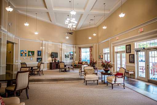 A large room with a lot of chairs and a table in the middle.