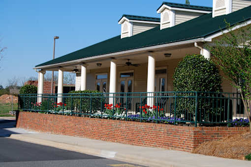 A house with a green roof and a porch with a railing.