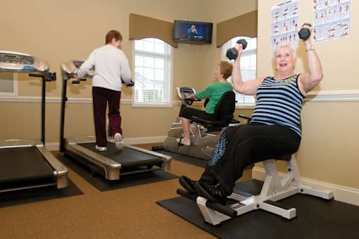 Three women exercising in a gym.