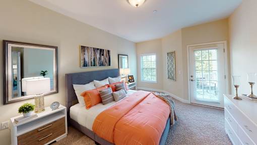A bedroom with a large bed and a painting on the wall.