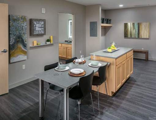 A modern kitchen with a dining table set for two.