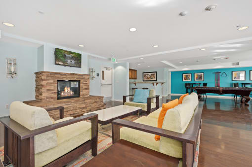 a living room with couches a fireplace and a pool table
