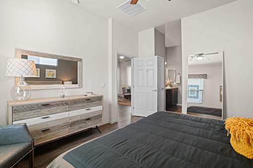A bedroom with a bed, dresser, and mirror.