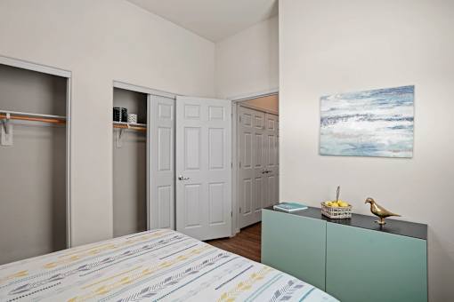 A room with a bed, a cabinet, and a painting on the wall.