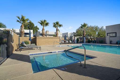 A swimming pool surrounded by palm trees and a fence.