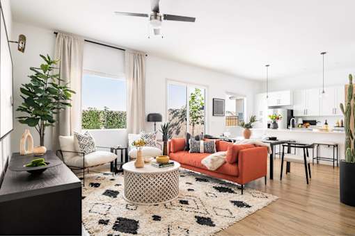 A living room with a red couch and a black and white rug.