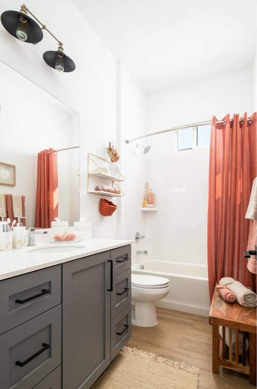 A bathroom with a white counter top and a white toilet.