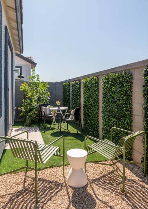 A patio with a table, chairs, and a vase.