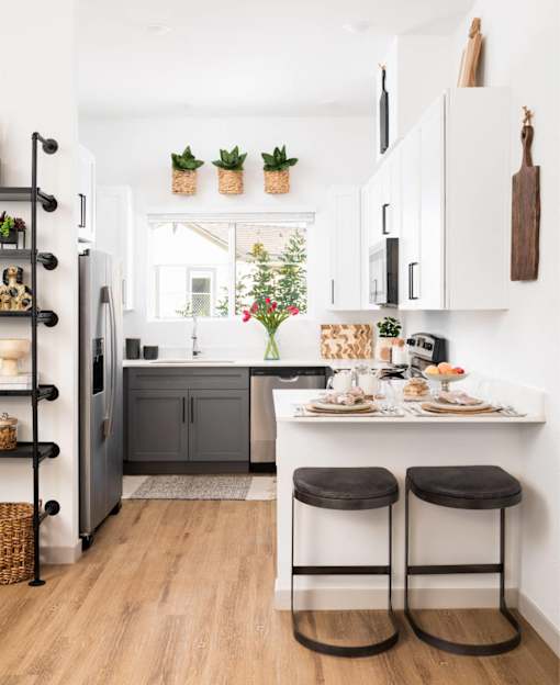 A kitchen with a table and two stools.