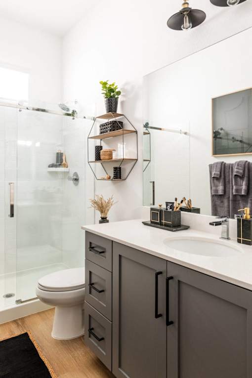 A bathroom with a white sink, a toilet, and a glass shower.