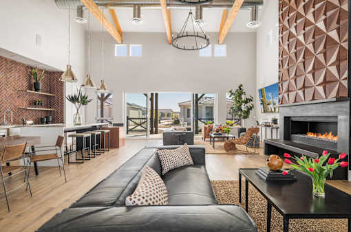 A modern living room with a black leather sofa and a fireplace.