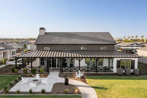 A modern house with a covered patio and a well-kept lawn.