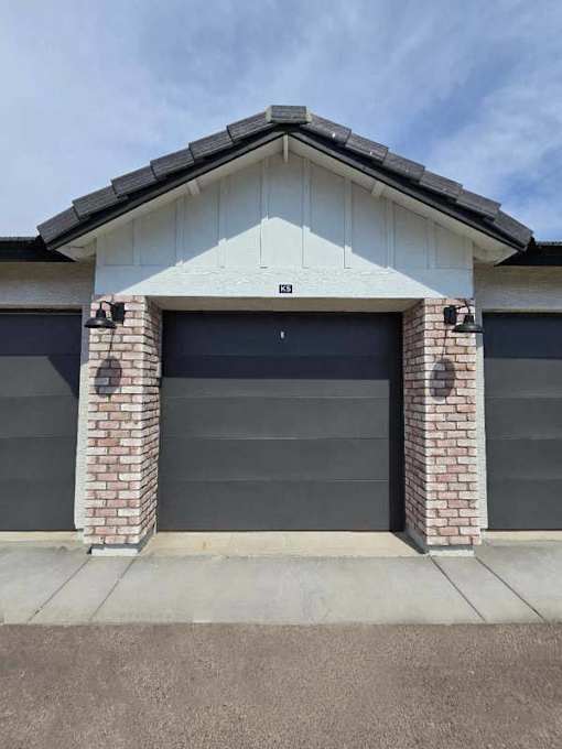 A garage door is closed and has the number 23 on it.