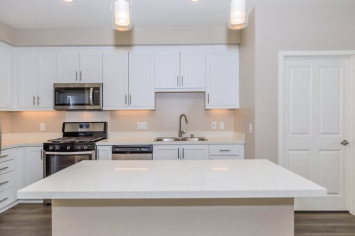 a kitchen with white cabinets and a white counter top