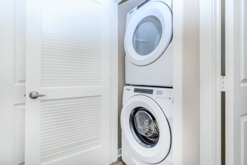a white washer and dryer in a laundry room with a door